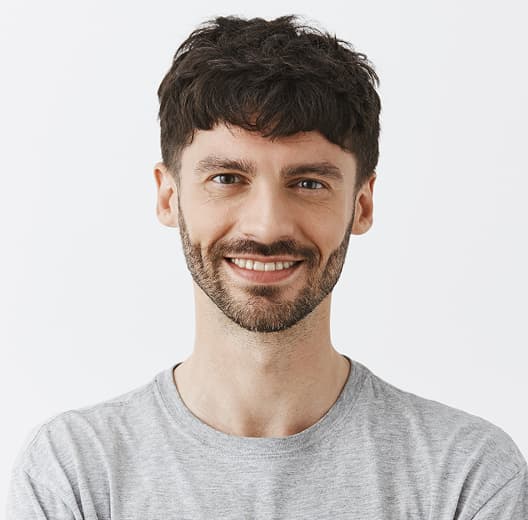 Confident handsome guy posing against white wall